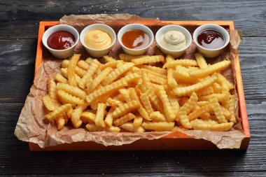 Patates kızartması sosları ile büyük ahşap tepsi