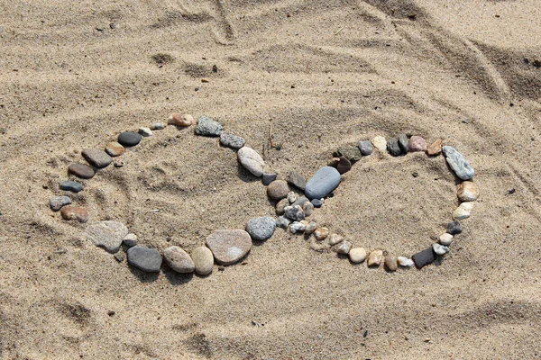 Kis sziklák fekszenek a homokos parton — Stock Fotó