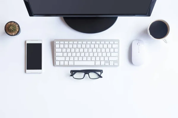 White desk office with laptop, smartphone and other work supplie