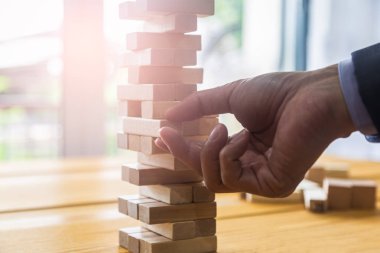 Business man gambling placing wooden block. Business concept  in