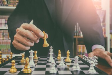 Satranç tahtasında satranç, iş adamı geçmişinin arkasında. Finansal bilgi ve pazarlama stratejisi analizi sunma konsepti. Küresel ekonomi ve dijital ticarete yönelik yatırım hedefi.