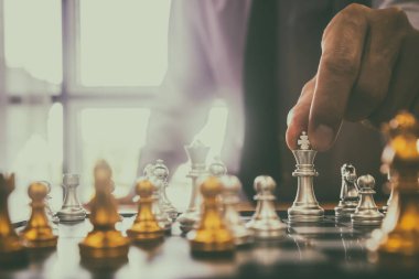 Satranç tahtasında satranç, iş adamı geçmişinin arkasında. Finansal bilgi ve pazarlama stratejisi analizi sunma konsepti. Küresel ekonomi ve dijital ticarete yönelik yatırım hedefi.