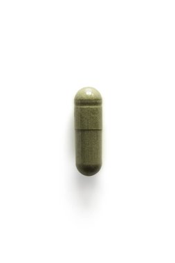 Andrographis paniculata hap kapsülü beyaz arka planda, kırpma yolu ve kopyalama alanı ile yeşile boyandı. Corona virüsü ya da kovid19 tedavisi için bitkiden alternatif tıbbi tedavi. Uyuşturucu ve tıp konsepti.