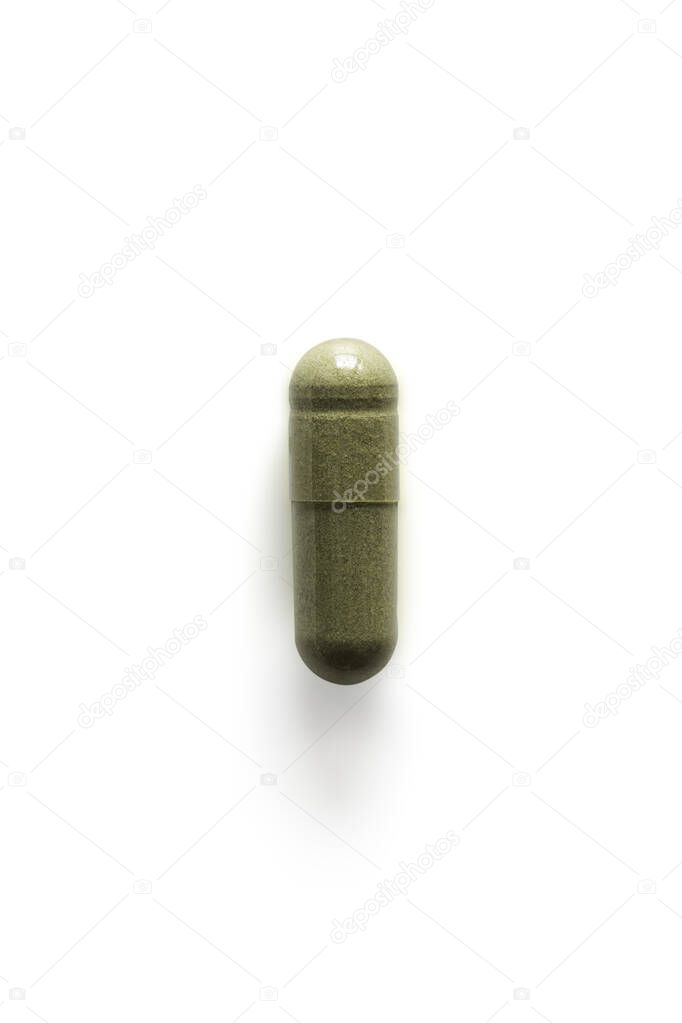 Andrographis paniculata pill capsule in green on white background with clipping path and copy space. Alternative medical from herb for treatment corona virus or covid19. Drug and medicine concept.