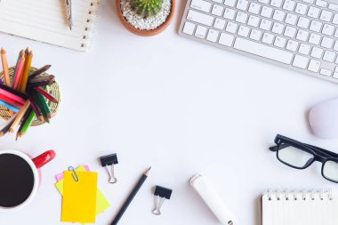 Bilgisayarlı beyaz masa ofisi, akıllı telefon ve bir fincan kahveli diğer iş malzemeleri. Metni kopyalamak için üst görünümü kullan. Desenci çalışma alanı düz masa üzerinde temel elementler yatıyordu.