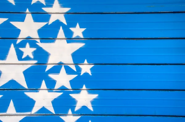 white stars on blue background painted on a closed shutter
