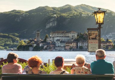 San Giulio Adası'na feribot için bekleyen Orta İtalya üst düzey turistler İtalya tekne