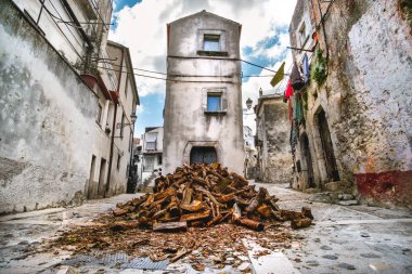 domestic heating firewood old in south italy village Vico del Gargano in Apulia clipart