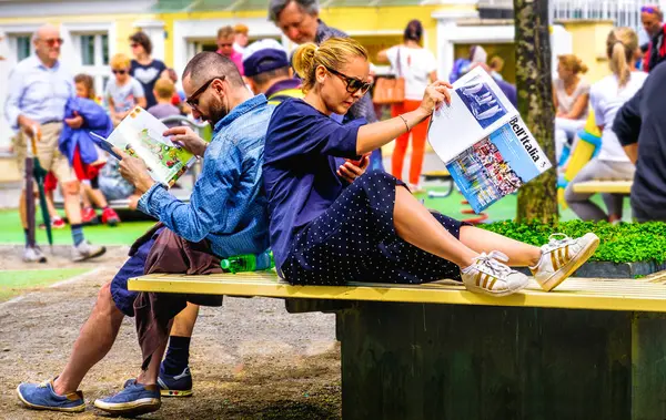 Jovem casal sentado no banco da cidade planejamento viagem para itália ler revistas de viagens — Fotografia de Stock