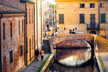 sıcak sesi ışıklar kırmızı tuğla eski binalar ve kanal, Comacchio, Ferrara eyaletinde, Emilia Romagna, İtalya köprüde üzerinde gün batımında romantik kaçamaklar İtalya'da,