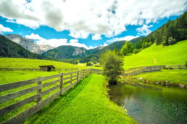 Paysage de montagne étang lac clôture en bois herbe verte grand angle horizon lointain — Photo