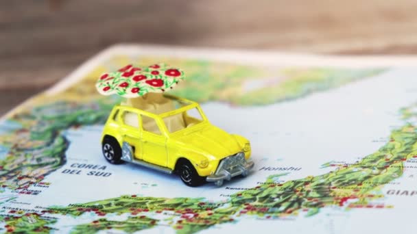 Carte du Japon avec une voiture jouet de scarabée jaune avec un parapluie blanc — Video