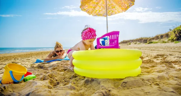 Petite fille bébé joue avec la piscine gonflable jaune sur la plage — Photo