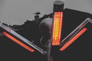 Isı kızılötesi lamba gaz verandası ısıtıcıları ve sokakta sıcak bir ışık direğinde propan.
