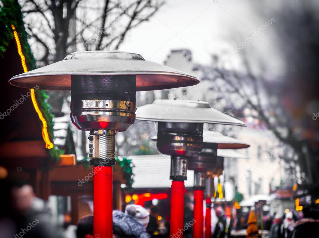 row of gas patio heaters with propane heat lamp on the street in winter day