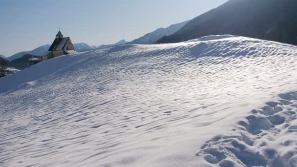 Berglandschap, pittoreske sneeuwvoetafdrukken in de winterochtend panoramische kerk — Stockvideo