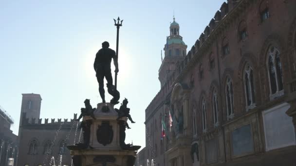 Olaszország Emilia Romagna régiójának bolognai helyi nevezetessége - Neptunusz-szobor vagy Fontana del Nettuno szökőkút és a városháza épülete háttérhomályban — Stock videók