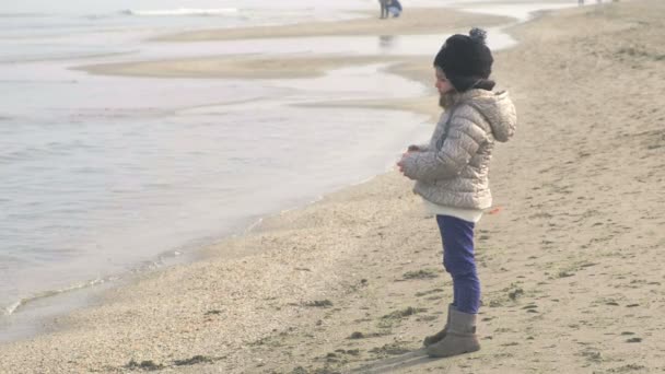 Дитина дивиться і дивиться на море в зимовій ностальгічній сцені — стокове відео