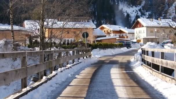 Pan tiro fundo de casas cobertas de neve e estrada vazia Imagens de alta qualidade — Vídeo de Stock