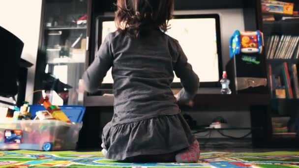 Bebê recém-nascido assistir tv no tapete em meias sala de estar visão traseira — Vídeo de Stock