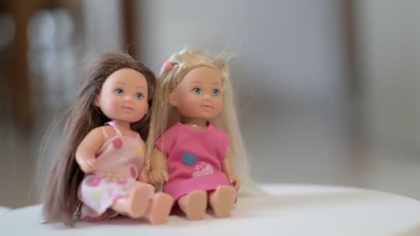 Sister dolls two twin game set children blonde brunette toys hair blue eyes blur background — Stock Video