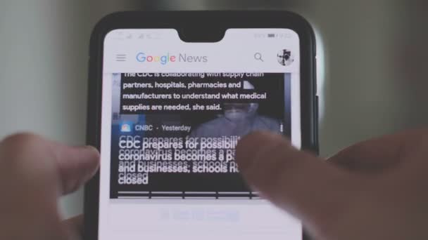 Rolos de mão e ler o Coronavirus covid-19 notícias artigos em um smartphone em Bolonha — Vídeo de Stock