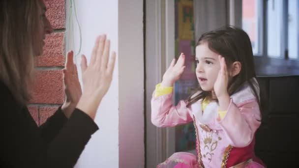 Aplaudiendo manos jugar pastel de empanada juego mamá y bebé niña vestido como princesa para el carnaval — Vídeo de stock