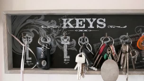 Key hanger horizontal panning background of many keychains in holiday home — Stock Video