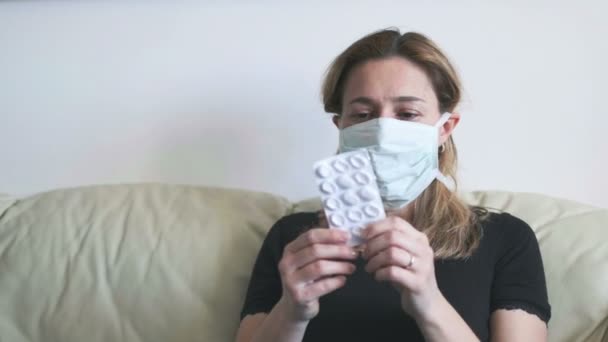 Drogas máscara mulher - emergência de cuidados de saúde doente mulher com comprimidos bolha - antibióticos coronavírus inúteis contra covid-19 — Vídeo de Stock