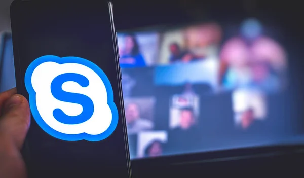 Hand use videoconference app icon of Skype for Business on smartphone. — Stock Photo, Image