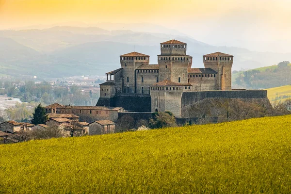 Wahrzeichen Italiens, das Fantasieschloss Torrechiara in der Nähe von Parma - Italien mit gelb-warmgetöntem Gras und himmelblauem Vintage-Look mit Kopierraum — Stockfoto