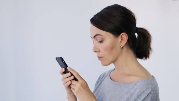 Ung vacker kvinna skriver ett Sms till sin mobiltelefon — Stockvideo