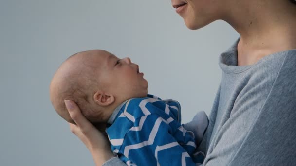 Mother holds a newborn baby kisses him and embosom — Stock Video