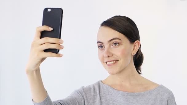 Sorrindo senhora fazendo selfie em um fundo branco — Vídeo de Stock