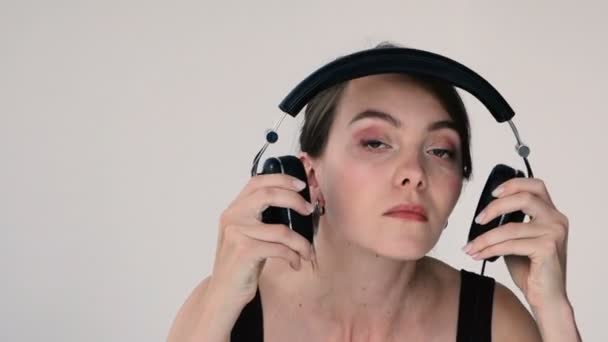 Mujer pone auriculares sutilmente balancea a lo largo de la música — Vídeo de stock