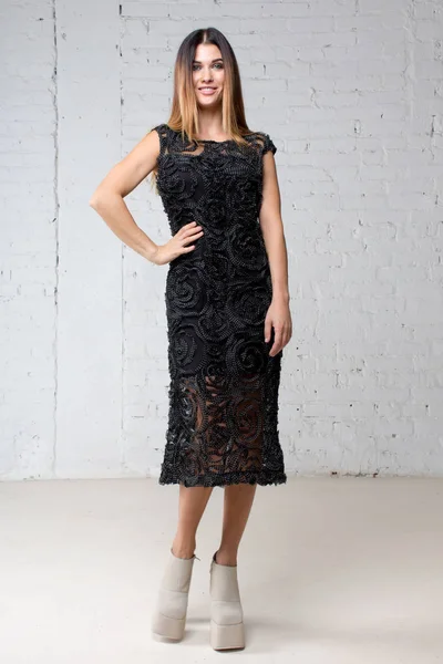 Woman is standing in a black evening dress studio — Stock Photo, Image