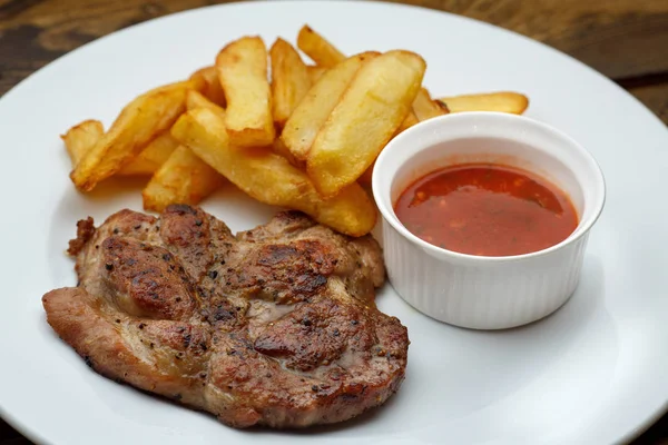 Carne a la parrilla con papas fritas y salsa — Foto de Stock