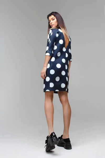 Women in short polka dot dress back playfully look — Stock Photo, Image