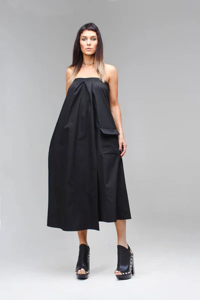 Модель, которая держит платье в руке черный сарафан — стоковое фото
