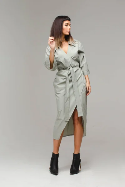 Mulher de pé de casaco cinza e olhando para os lados — Fotografia de Stock