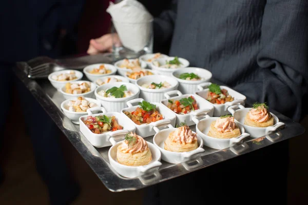 A waiter with a tray of snacks at a banquet — Stock Photo, Image