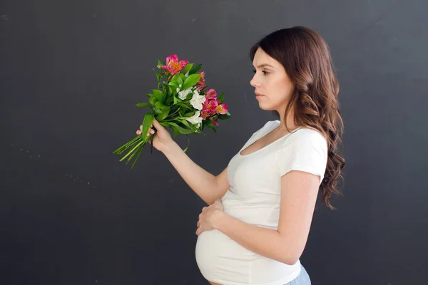 गर्भवती महिला बुकेट के साथ पोज़िंग — स्टॉक फ़ोटो, इमेज