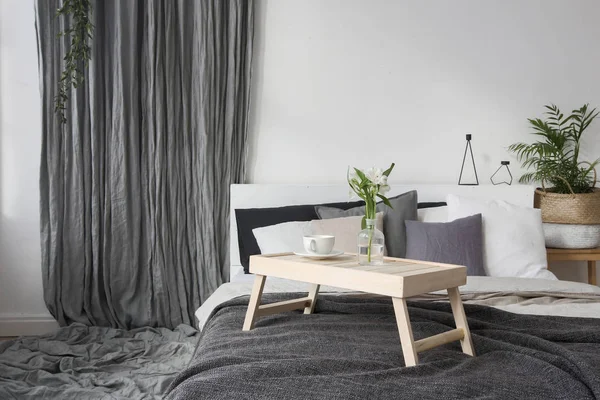 Interior del dormitorio con una pequeña mesa en la cama —  Fotos de Stock