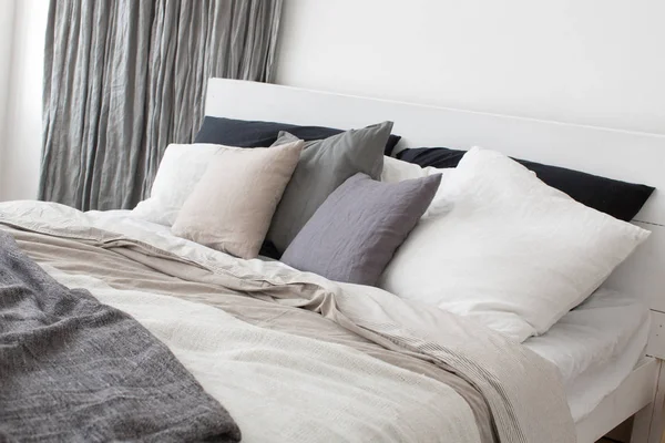 Säng med grå och vita sängkläder — Stockfoto