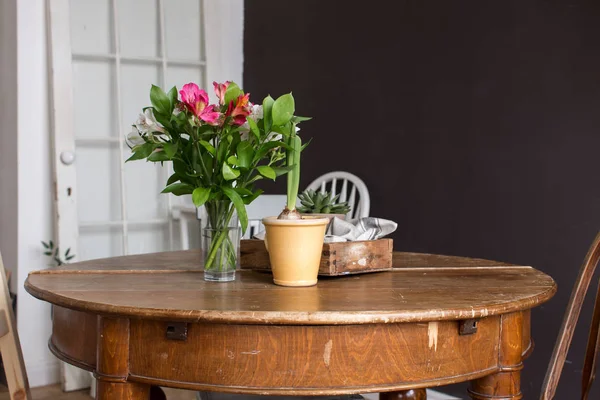 Vase und Topf mit Blumen auf dem Tisch — Stockfoto