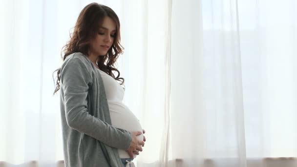 Zwangere vrouw aanraken van de buik met ogen gesloten — Stockvideo