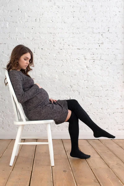Портрет беременной женщины, сидящей на стуле — стоковое фото