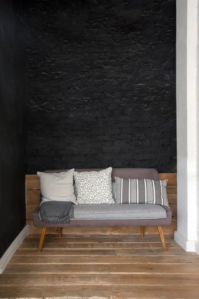 Sofá cerca de la pared negra —  Fotos de Stock