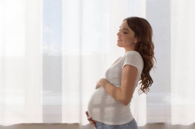 Hamile kadın karnına dokunuyor.