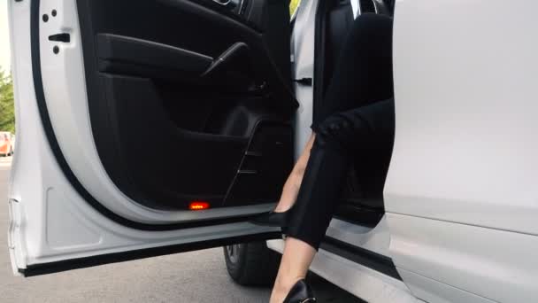 Женские каблуки выходят из дорогой машины — стоковое видео
